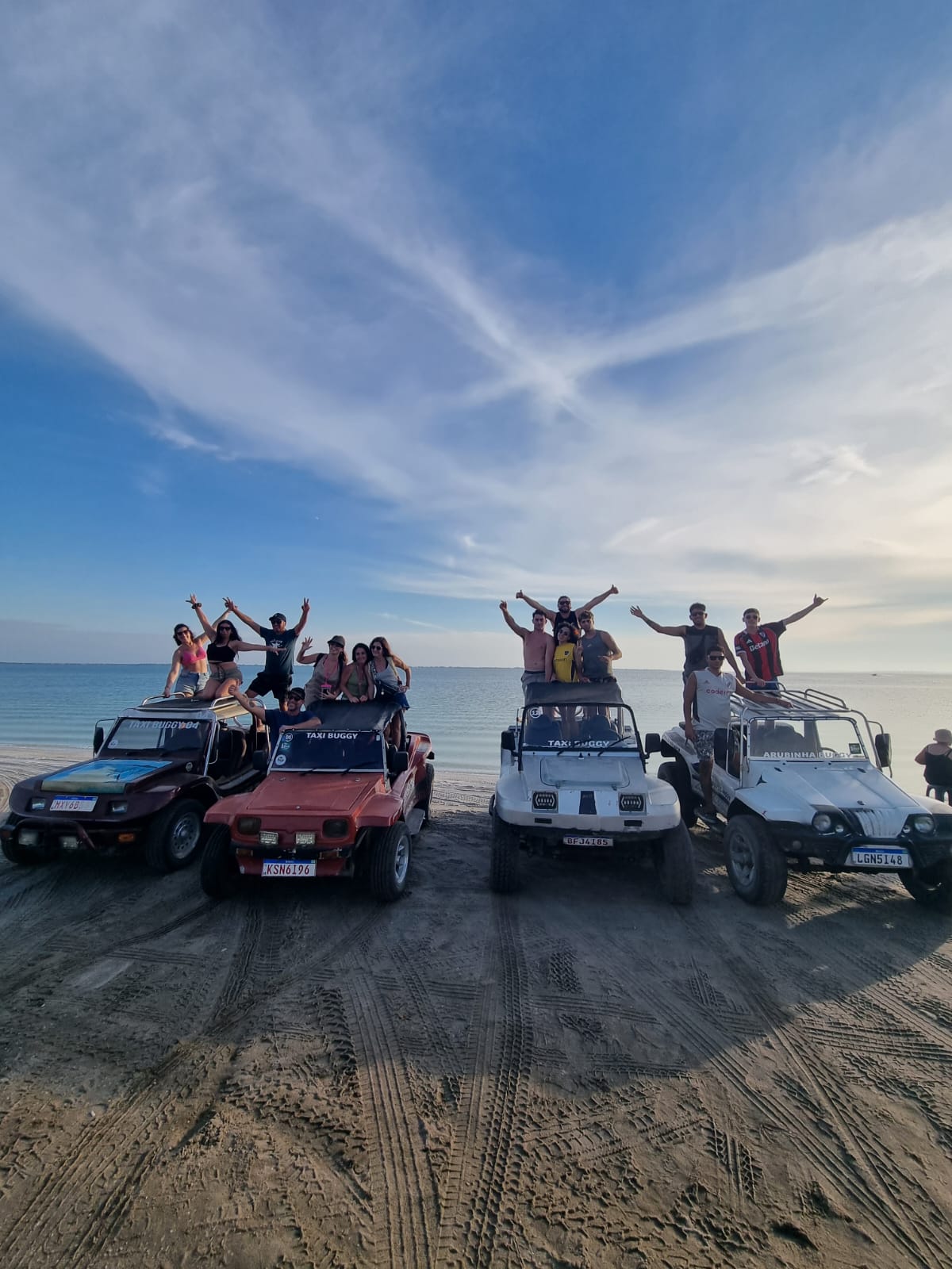 Grupo de pasajeros sobre los buggies en la playa de Arubinha